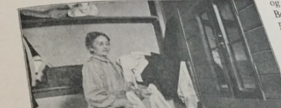 Gammlet fotografi at en kvinde, der står med vasketøj