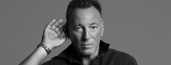 Nærbillede af Springsteen med en hånd bag øret