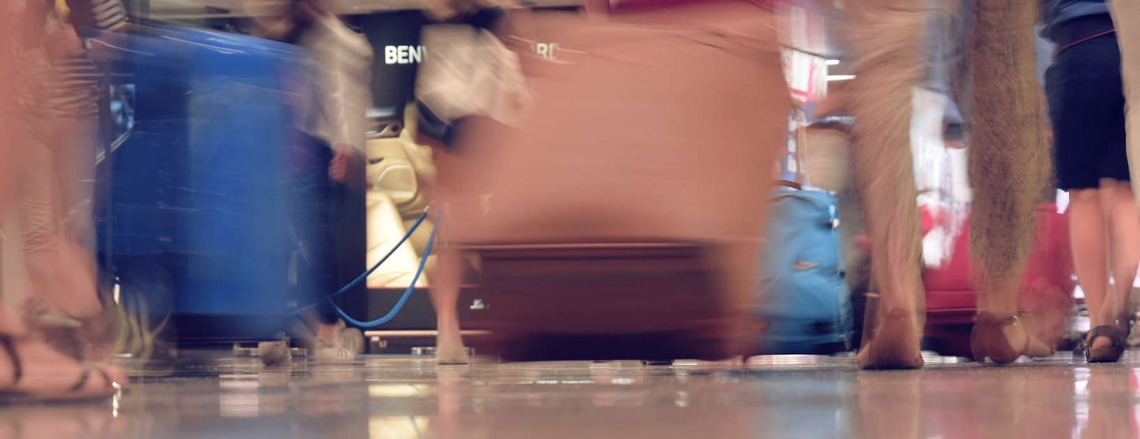 Sløret billede af rullekufferter i en lufthavn