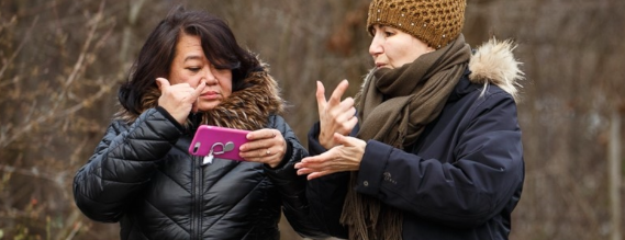 To kvinder står udendørs og taler tegnsprog
