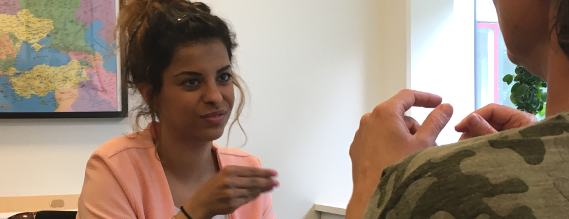 Ung kvinde med mørk hud samtaler på tegnsprog